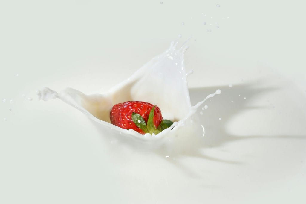 pexels-photo-2064359-2064359 A vibrant strawberry makes a splash in creamy white milk, showcasing freshness and vivid colors.